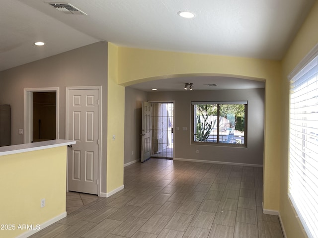 10817 W Wilshire Dr, Avondale, AZ 85392 - spare room featuring visible vents, baseboards, lofted ceiling, recessed lighting, and arched walkways
