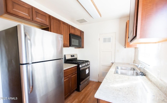 602 E San Juan Ave, Phoenix, AZ 85012 - kitchen with sink, light stone countertops, stainless steel appliances, and light hardwood / wood-style flooring