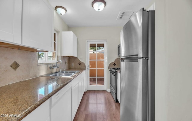602 E San Juan Ave, Phoenix, AZ 85012 - kitchen with stone countertops, stainless steel appliances, white cabinets, decorative backsplash, and sink