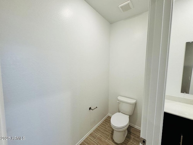 47267 W Mellen Ln, Maricopa, AZ 85139 - bathroom featuring wood finish floors, toilet, vanity, and baseboards