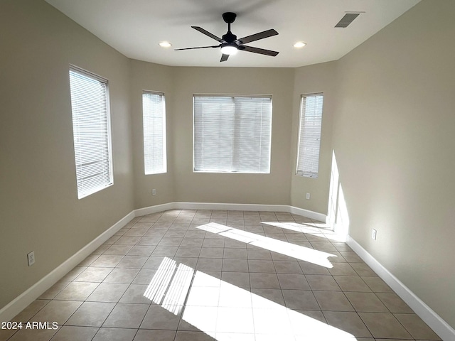 empty room with ceiling fan and light tile patterned flooring