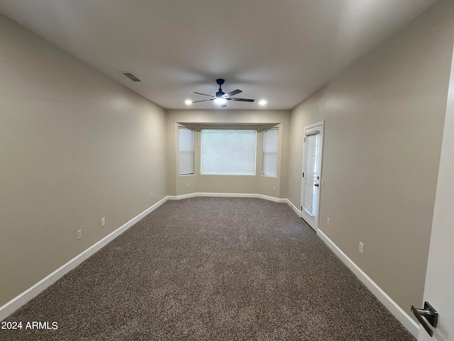 unfurnished room with ceiling fan and carpet