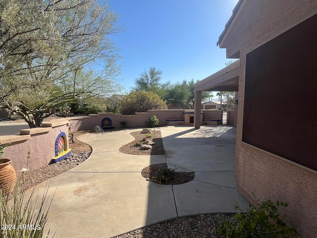 view of patio with a hot tub and an outdoor kitchen