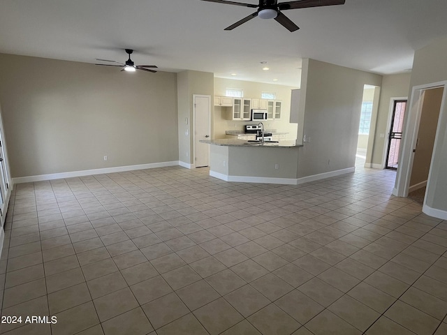 unfurnished living room featuring ceiling fan, light tile patterned floors, and sink