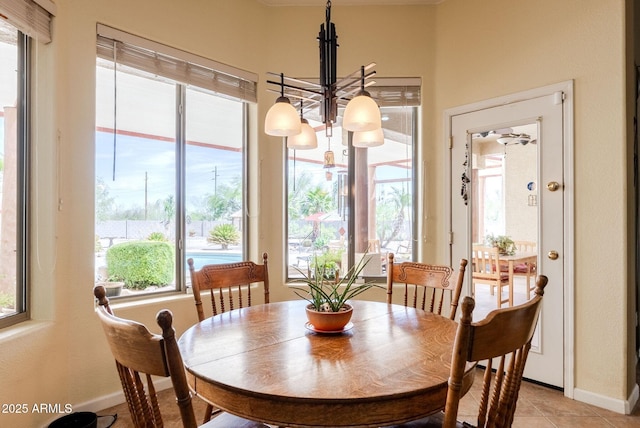 dining space featuring baseboards, a chandelier, and light tile patterned floors