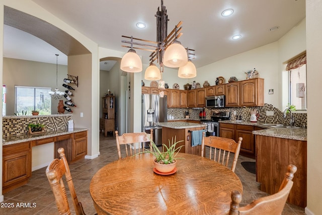 dining space with recessed lighting, arched walkways, dark tile patterned floors, and a notable chandelier