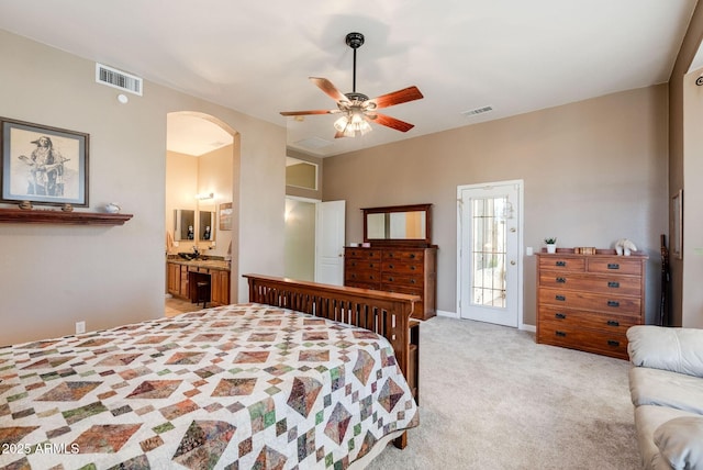 bedroom featuring arched walkways, light colored carpet, visible vents, and a ceiling fan