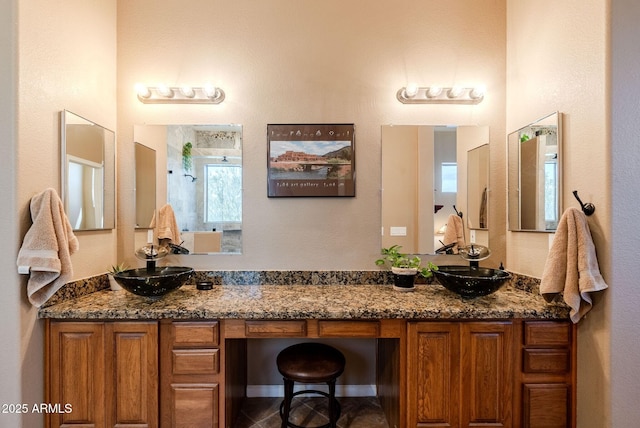 full bath featuring double vanity, a sink, and walk in shower