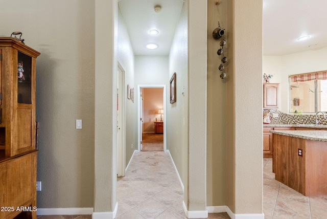 hallway with a sink and light tile patterned floors