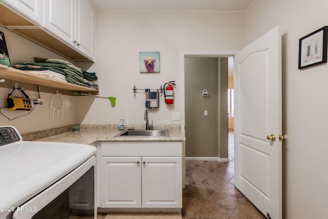 laundry room featuring a sink, cabinet space, and washer / clothes dryer