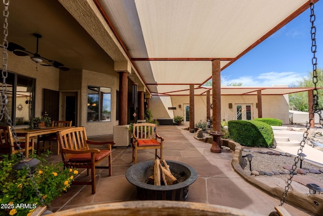 view of patio featuring a ceiling fan and an outdoor fire pit