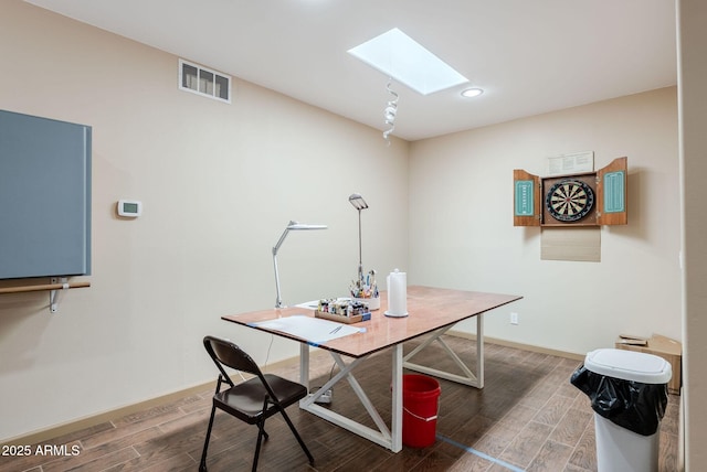 home office featuring baseboards, a skylight, visible vents, and wood finished floors