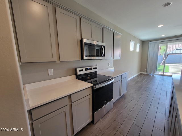 kitchen featuring gray cabinetry, appliances with stainless steel finishes, and light hardwood / wood-style flooring