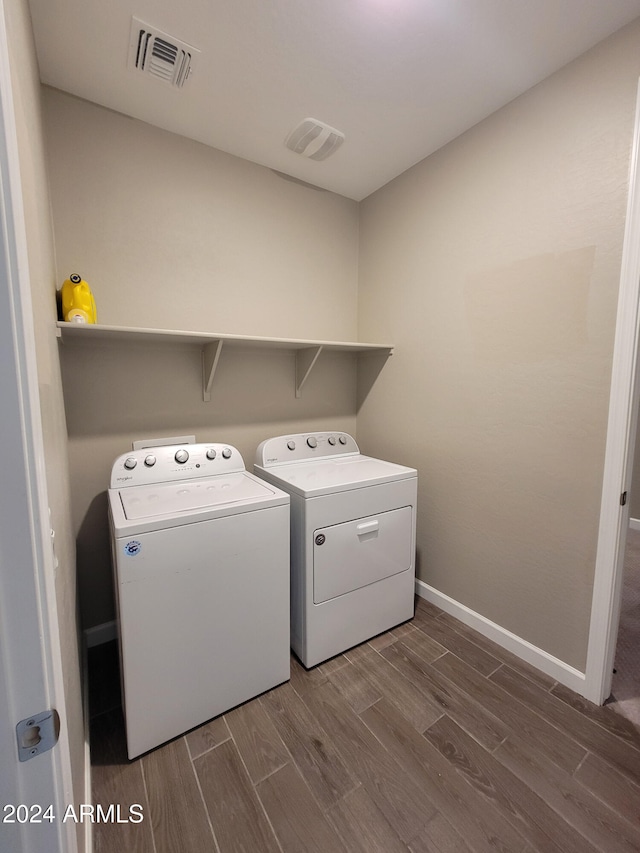 washroom with hardwood / wood-style floors and separate washer and dryer