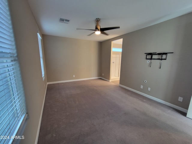 carpeted spare room featuring ceiling fan