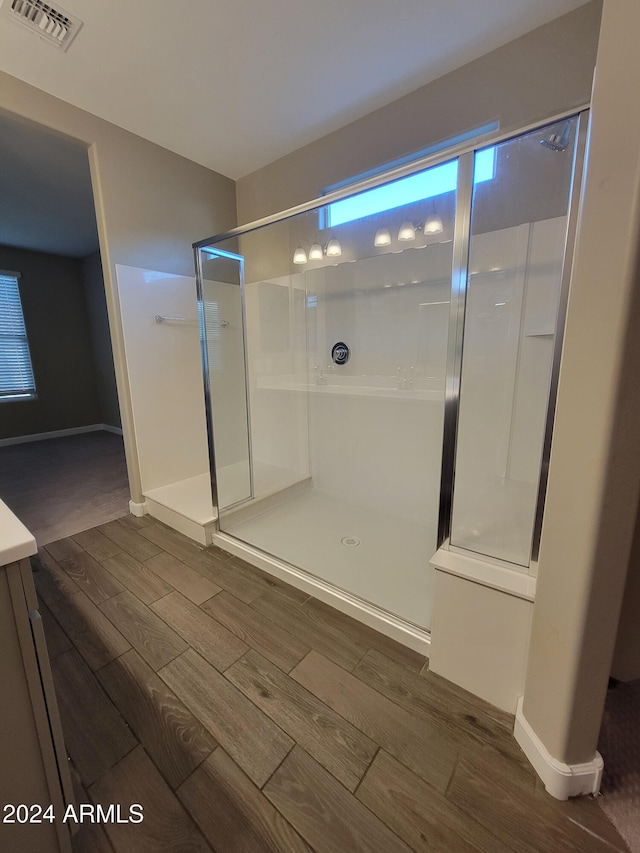 bathroom featuring hardwood / wood-style flooring and walk in shower