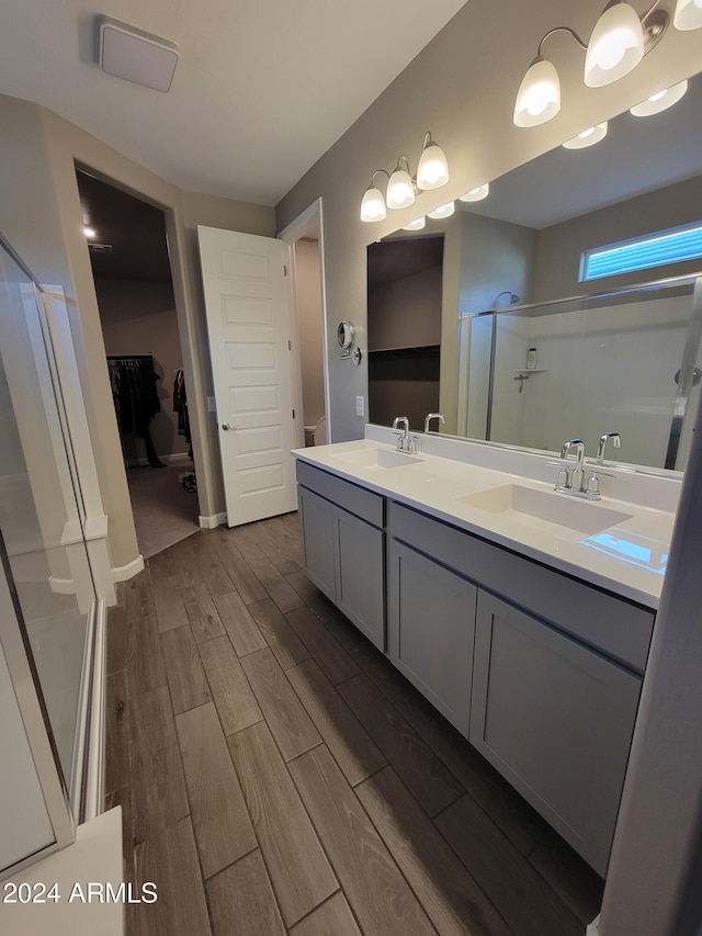 bathroom featuring hardwood / wood-style floors, vanity, and walk in shower