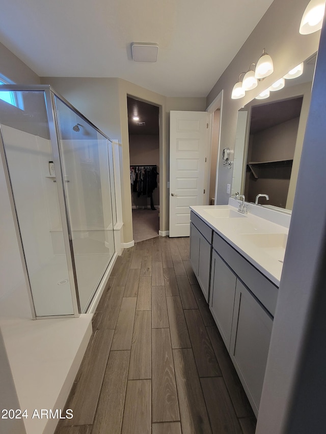 bathroom featuring vanity, hardwood / wood-style flooring, and a shower with door