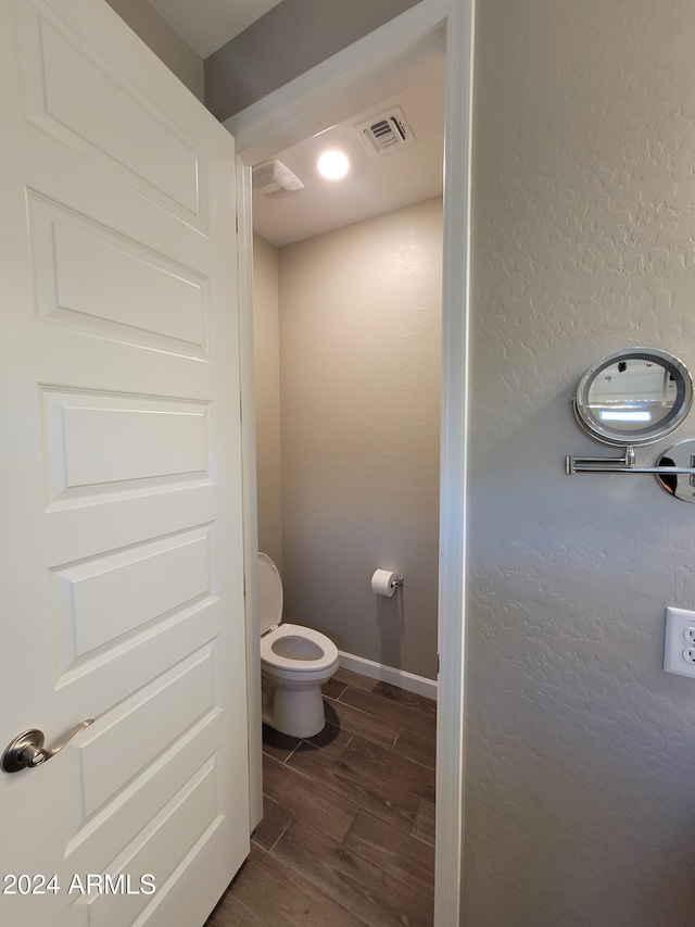 bathroom featuring hardwood / wood-style flooring and toilet