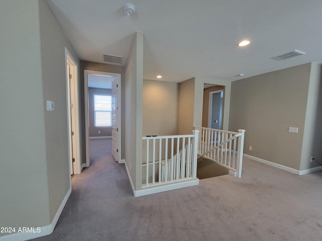 hallway with light colored carpet