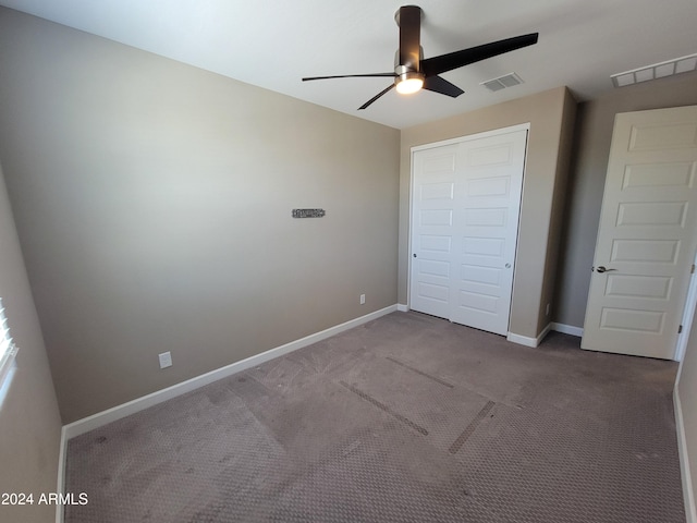 unfurnished bedroom featuring ceiling fan, light carpet, and a closet