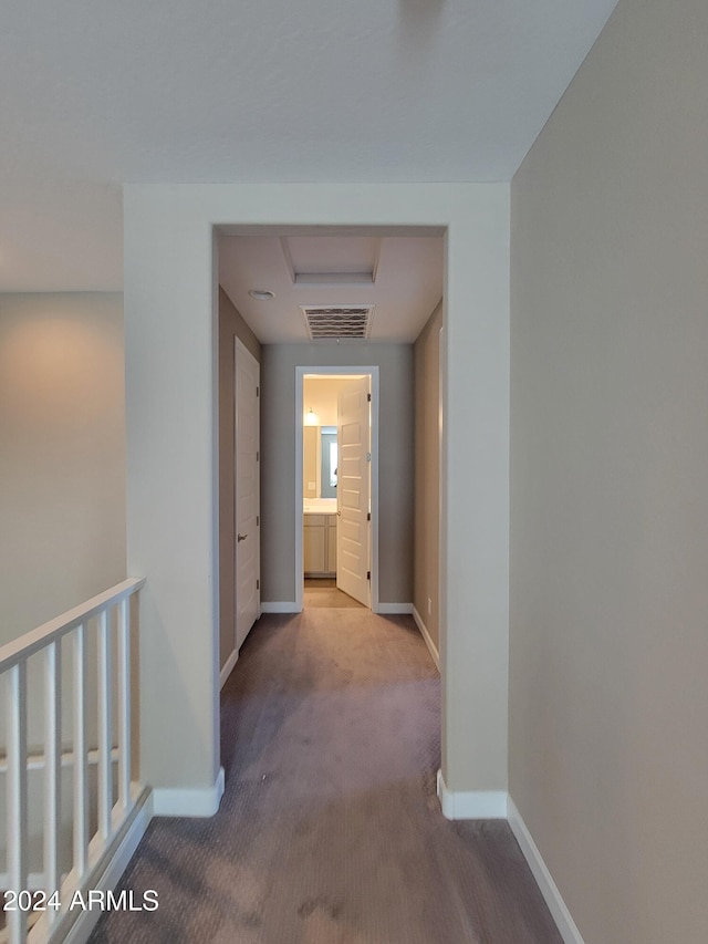 hallway featuring light colored carpet