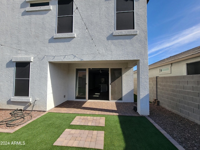 back of house with a yard and a patio