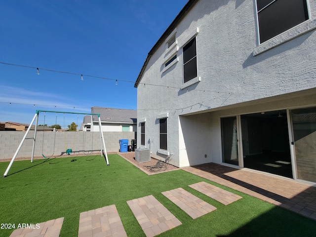 view of yard with a playground, central AC, and a patio