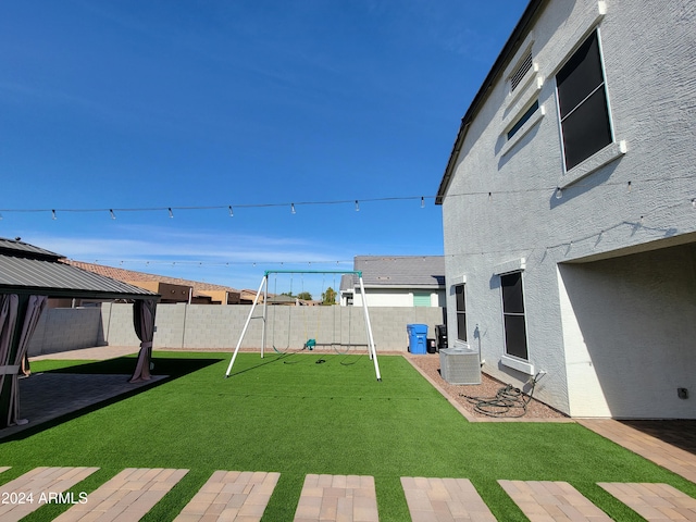 view of yard with a gazebo, a playground, and central air condition unit