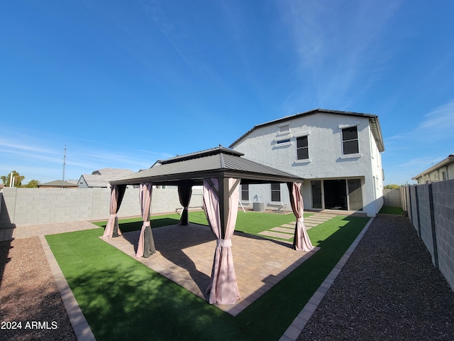 rear view of house with a gazebo and a lawn