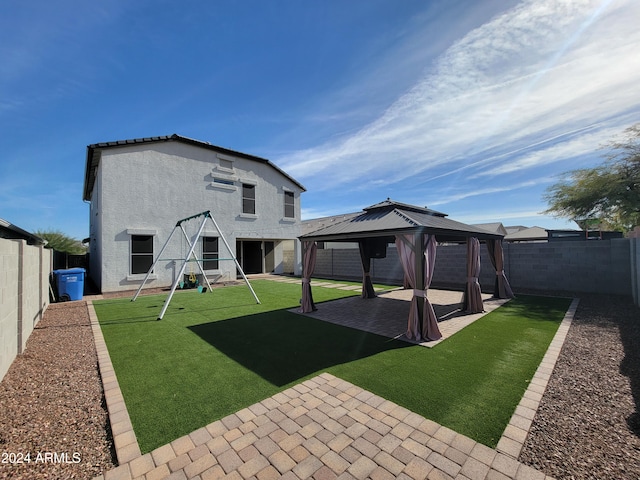 rear view of property with a gazebo and a lawn