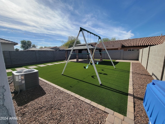 view of yard with a playground and central air condition unit