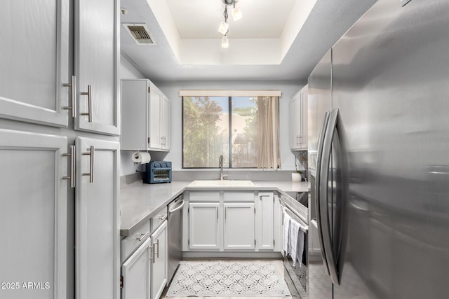 10863 N 117th Pl, Scottsdale, AZ 85259 - kitchen with appliances with stainless steel finishes, a sink, a raised ceiling, and light countertops