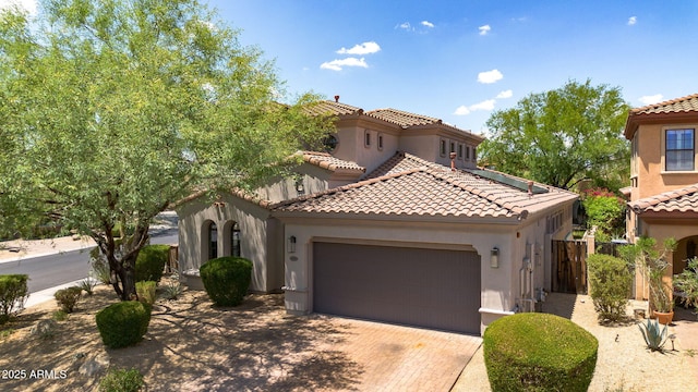 9904 E S Bend Dr, Scottsdale, AZ 85255 - mediterranean / spanish home with stucco siding, an attached garage, decorative driveway, and a tiled roof