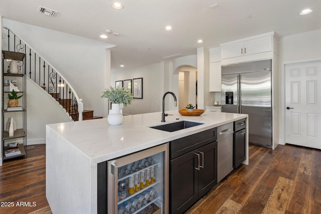 9904 E S Bend Dr, Scottsdale, AZ 85255 - kitchen featuring stainless steel appliances, a sink, wine cooler, arched walkways, and a center island with sink