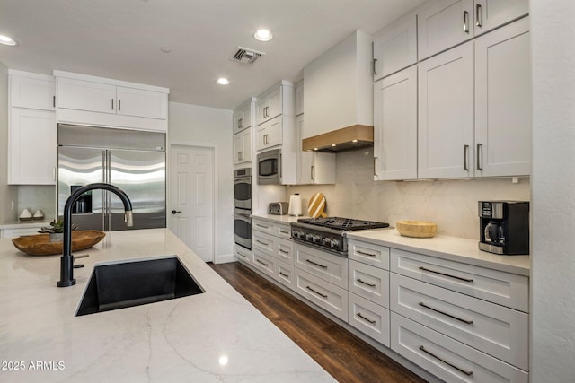 9904 E S Bend Dr, Scottsdale, AZ 85255 - kitchen with built in appliances, a sink, custom range hood, tasteful backsplash, and light stone counters