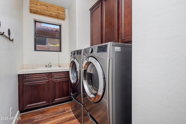 9904 E S Bend Dr, Scottsdale, AZ 85255 - washroom featuring cabinet space, washer and dryer, dark wood-type flooring, and a textured wall
