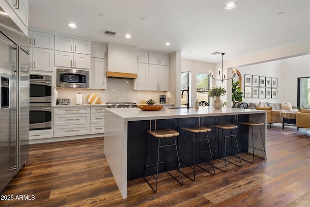9904 E S Bend Dr, Scottsdale, AZ 85255 - kitchen with built in appliances, a breakfast bar, recessed lighting, dark wood-type flooring, and a sink