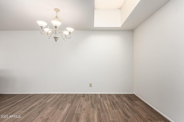 spare room featuring dark hardwood / wood-style floors and a notable chandelier