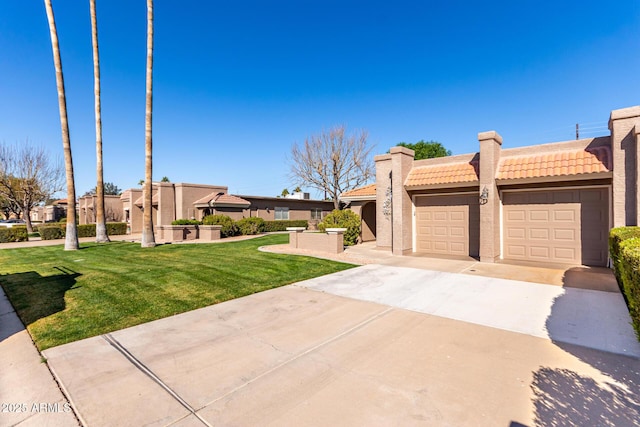 pueblo revival-style home featuring a garage and a front yard