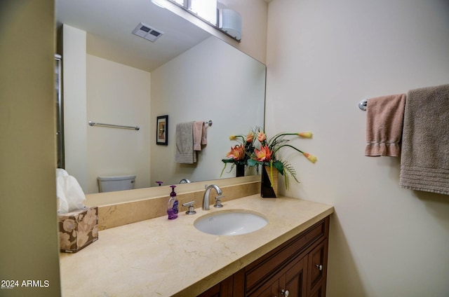 bathroom featuring vanity and toilet