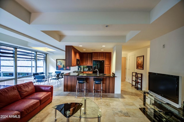 living room featuring a tray ceiling and sink