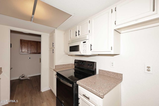 15801 N 29th St N Unit 20, Phoenix, AZ 85032 - kitchen with black electric range, white microwave, wood finished floors, white cabinets, and baseboards