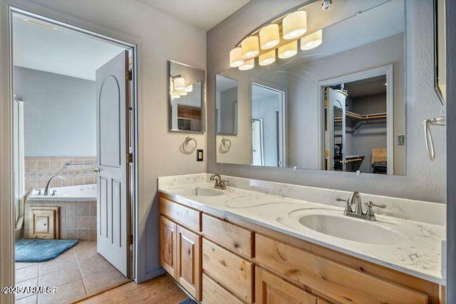 full bathroom featuring a sink, a spacious closet, double vanity, and tile patterned flooring