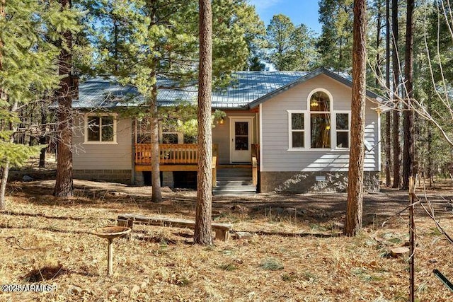 view of front facade featuring crawl space, covered porch, and metal roof