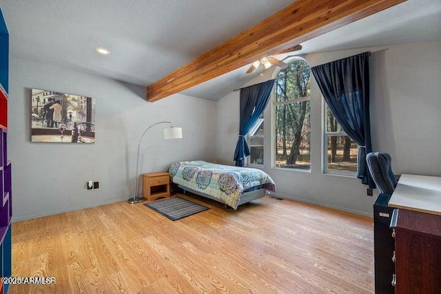 bedroom featuring lofted ceiling with beams, baseboards, and wood finished floors