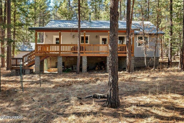 exterior space featuring stairway and metal roof