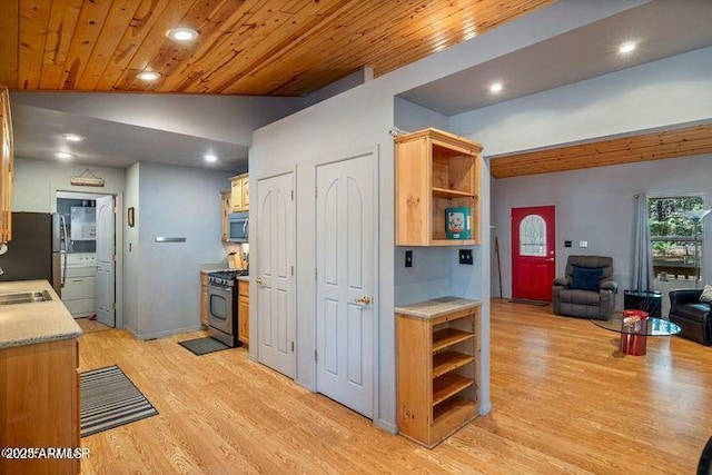 kitchen with open shelves, lofted ceiling, stainless steel appliances, light countertops, and light wood-type flooring