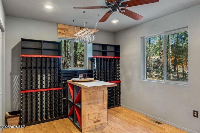 wine room with recessed lighting, visible vents, baseboards, and wood finished floors