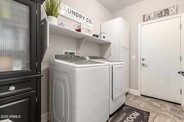 washroom with washer and dryer and cabinets